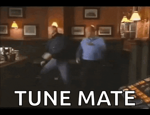 two men are dancing in a bar and the words tune mate are on the bottom