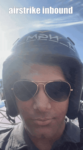 a man wearing sunglasses and a helmet that says airstrike inbound on it