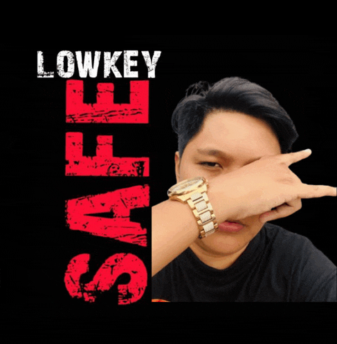 a man wearing a watch covering his face in front of a poster that says lowkey staff