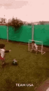 a young boy is kicking a soccer ball in a field with the words team usa written on the bottom