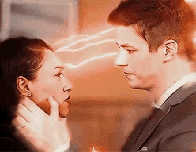 a man and a woman are looking at each other with lightning coming from their eyes .