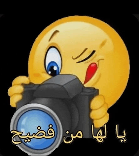 a cartoon smiley face is holding a camera with arabic writing below it