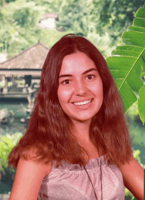 a woman with long red hair is smiling for the camera