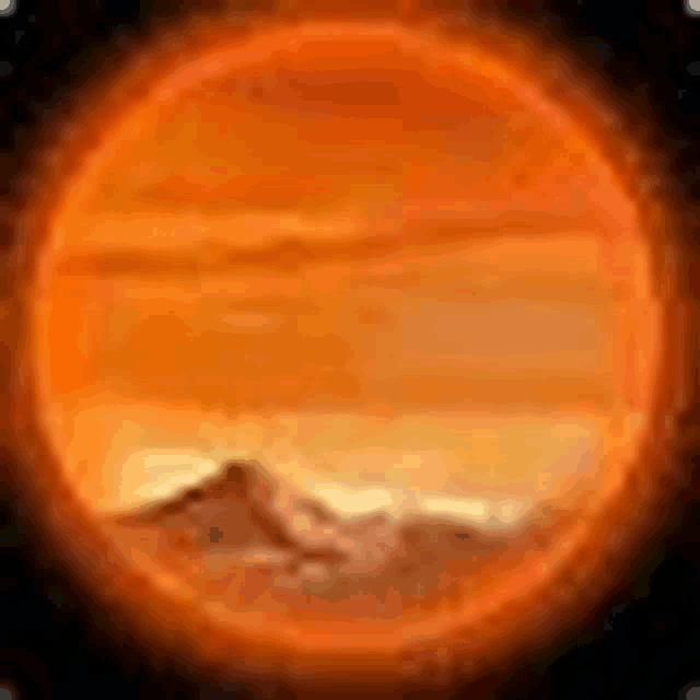 a picture of the sun with mountains in the background