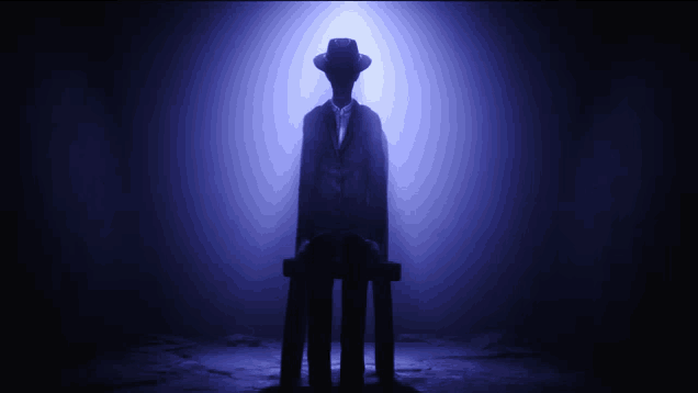 a silhouette of a man in a suit and hat sitting in a dark room