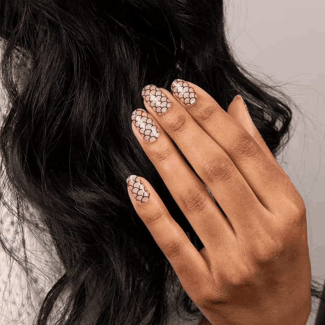 a close up of a woman 's nails with a snakeskin pattern