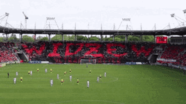 a soccer field with a large crowd in the stands and a banner that says ' cze ' on it