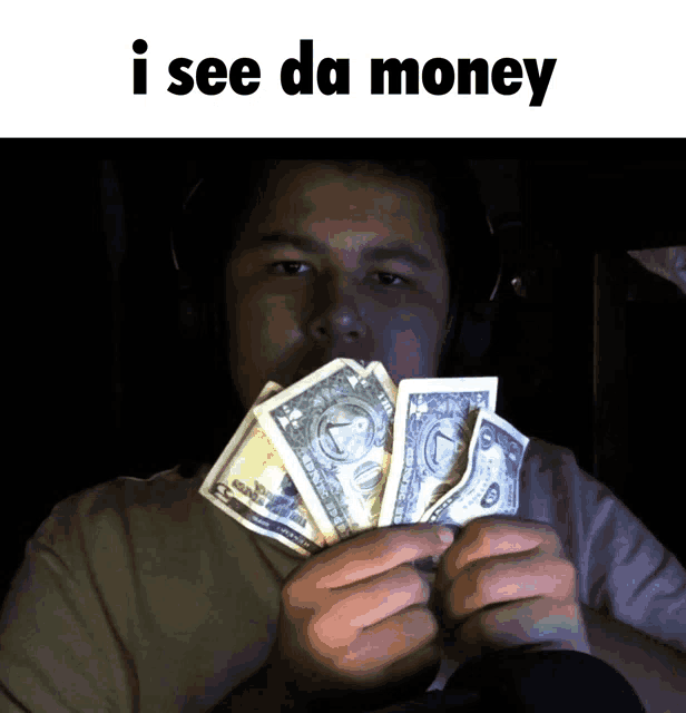 a man holding a bunch of money with the words i see da money below him