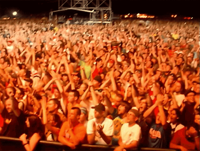 a crowd of people at a concert with a man wearing a shirt that says ' ucla ' on it