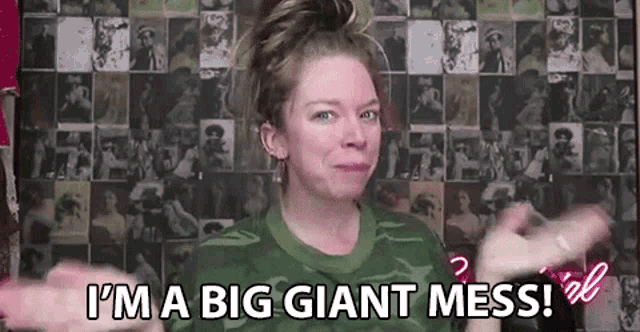 a woman is standing in front of a wall with pictures and says `` i 'm a big giant mess ''