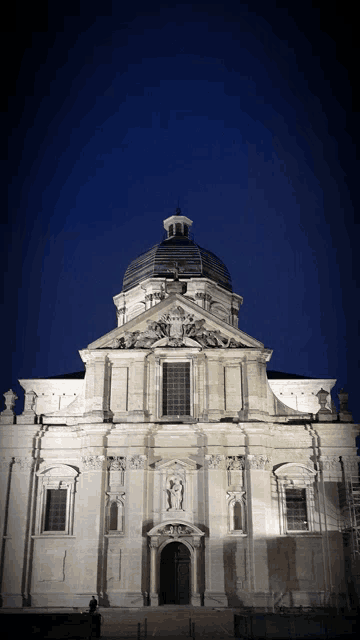 a large building with a dome and a statue on the front