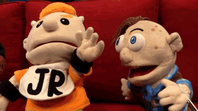 a puppet with a shirt that says jr is standing next to another puppet