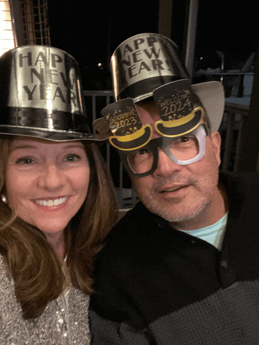 a man and a woman wearing new year hats and glasses