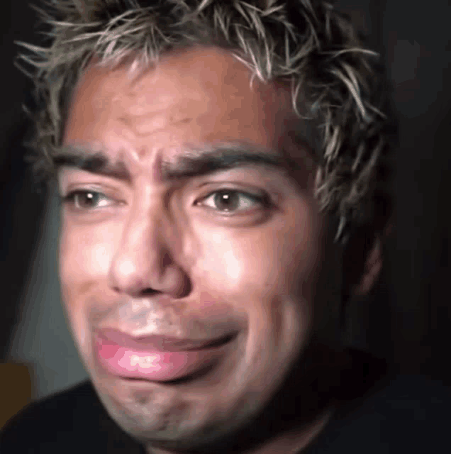 a close up of a man 's face with a tear running down his face .