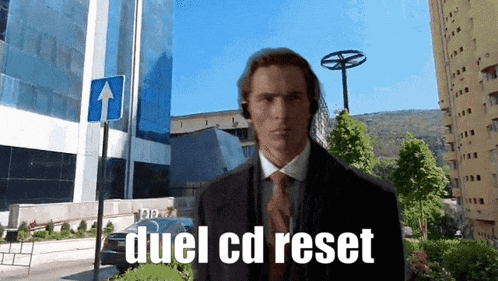 a man in a suit and tie is standing in front of a building with duel cd reset written on it