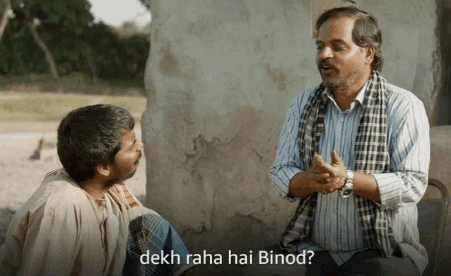 two men sitting next to each other with the words dekh raha hai binod