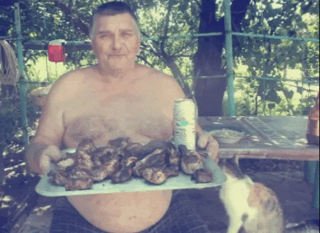 a shirtless man is holding a tray of food and a can of beer