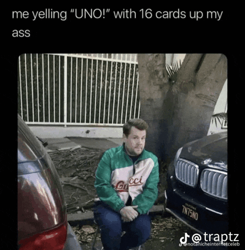 a man wearing a gucci jacket sits in front of a car