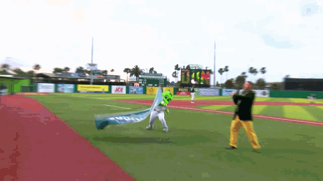 a man in a black jacket stands on a baseball field holding a flag that says ' ucsd ' on it