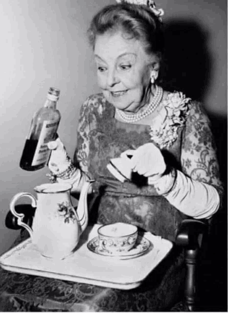 an older woman is pouring a drink into a cup