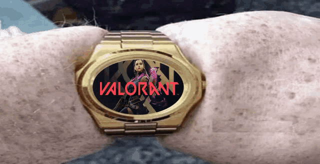 a gold watch with a picture of a woman and the words valorant on it