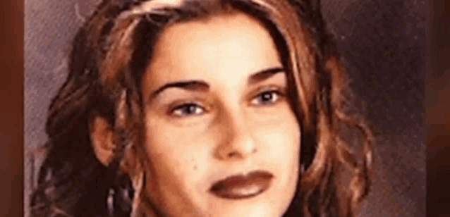 a woman with long hair and earrings is looking at the camera .