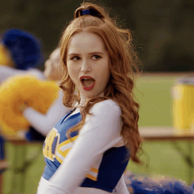 a cheerleader in a blue and yellow uniform with the letter a on it