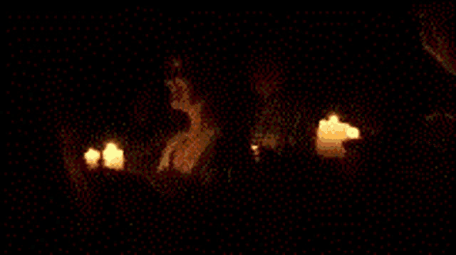 a blurry picture of a woman holding candles in the dark