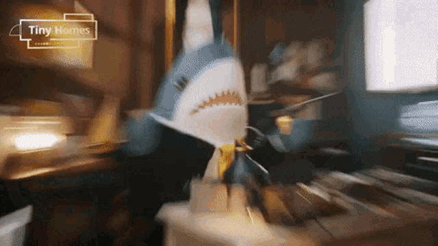 a stuffed shark is sitting on a table with tiny homes written on the bottom