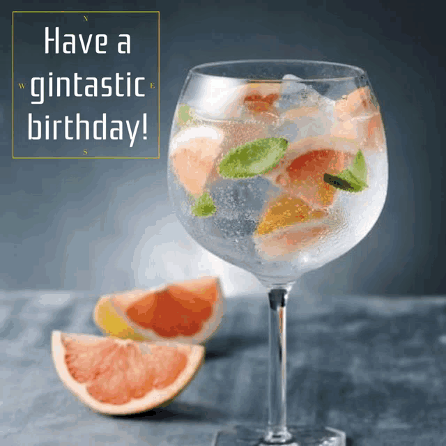 a glass of gin with grapefruit slices and the words have a gintastic birthday below it