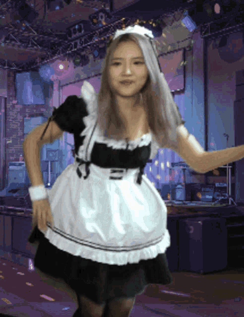 a woman in a maid costume is dancing in a dark room