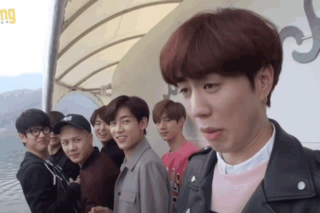 a group of young men are posing for a picture with one wearing a pink sweater