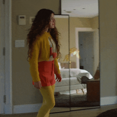 a woman is standing in front of a mirror wearing yellow tights