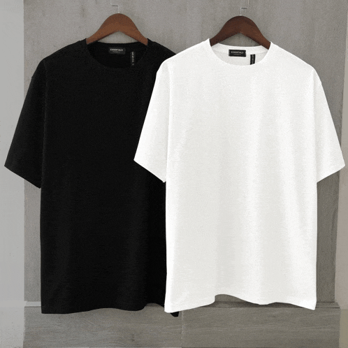 a black and a white t-shirt are hanging on a wooden hanger