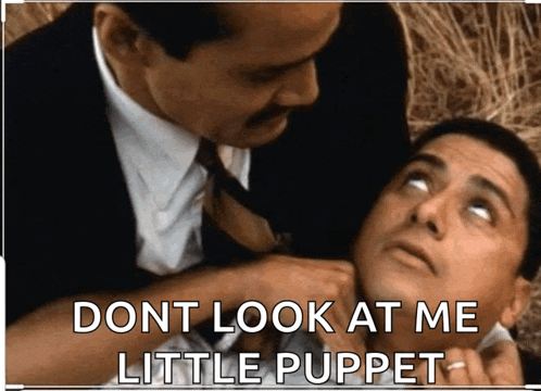 a picture of two men with the caption " dont look at me little puppet " on the bottom