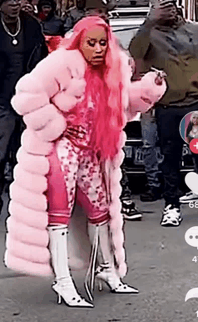 a woman with pink hair wearing a pink fur coat