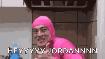 a man in a pink suit is standing in a kitchen and says hey yy jordannnn