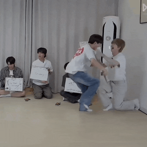 a group of people are playing a game and one of them is holding a sign that says ' i love you '