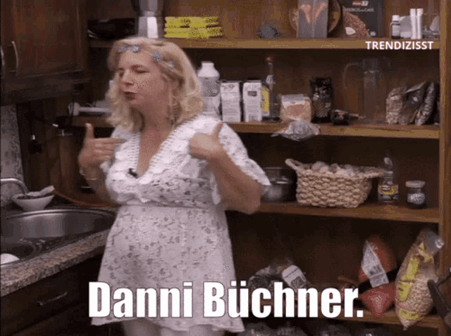 a woman in a white dress is giving a thumbs up in front of a pantry with the words danni buchner below her