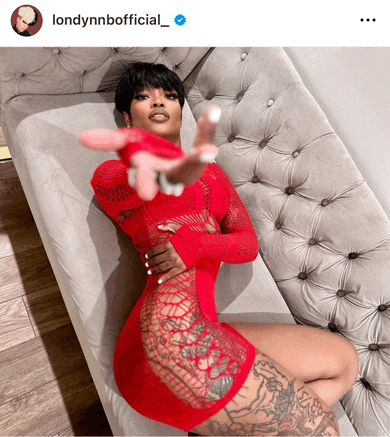 a woman in a red dress is laying on a grey couch with the caption londonnnofficial_