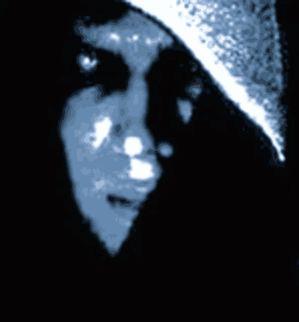 a close up of a person 's face with red eyes and a hood