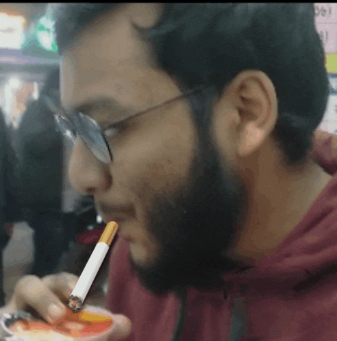 a man with a beard is smoking a cigarette