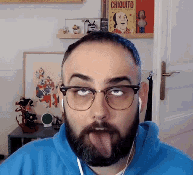 a man with glasses and a beard is sticking out his tongue in front of a shelf with chiquito books on it