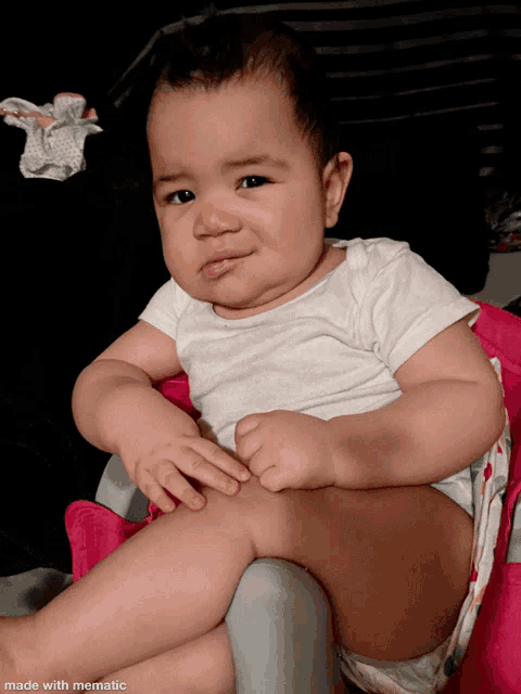 a baby is sitting in a pink high chair with a made with mematic watermark