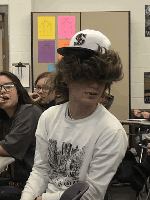 a boy wearing a white hat with a letter s on it