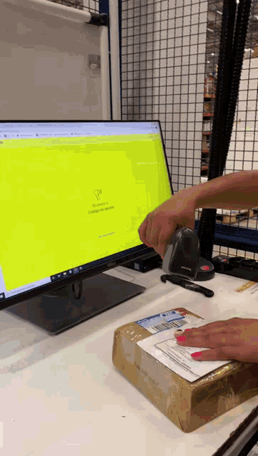 a person is using a scanner to scan a package on a dell monitor