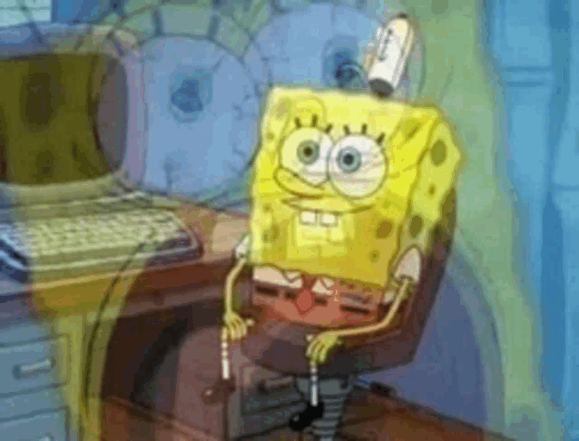 a cartoon of spongebob sitting in front of a computer