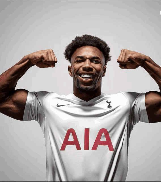 a man flexes his muscles wearing a white aia jersey