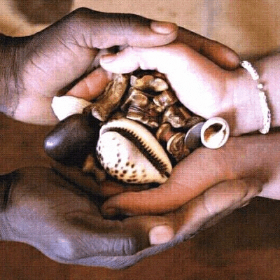 a man and a woman are holding a pile of rocks and shells in their hands .