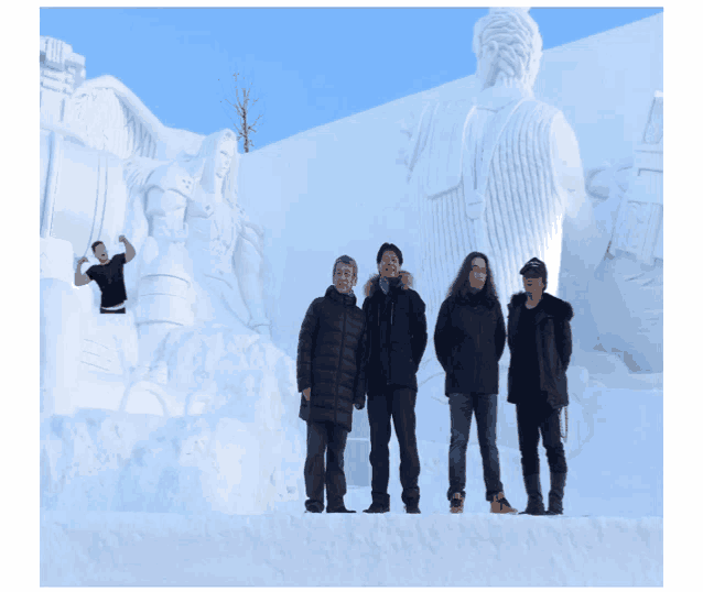 a group of people standing in front of a large statue